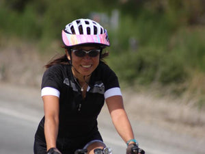 Female road biker riding with a Da Brim Rezzo helmet visor in pastel ribbons.