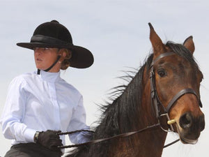 Female rider on horse. Rider is wearing the Da Brim Equestrian Petite Helmet Brim Visor in black.