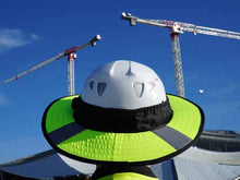 Load image into Gallery viewer, Da Brim PRO Tech Lite Construction helmet visor brim in fluorescent yellow with reflective on the job site. Rear view of brim pictured against background of a building and 2 cranes.